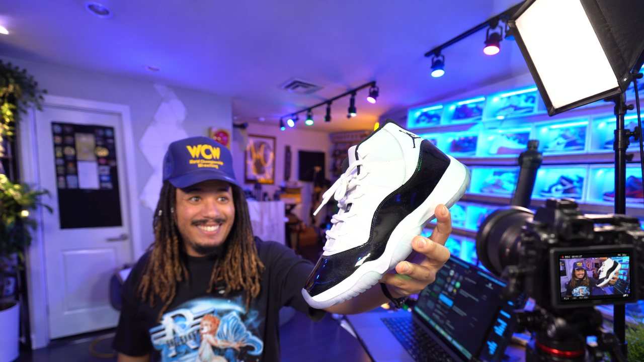 Tony filming a brand deal video in his studio: holding a sneaker to a camera on a tripod with a softbox